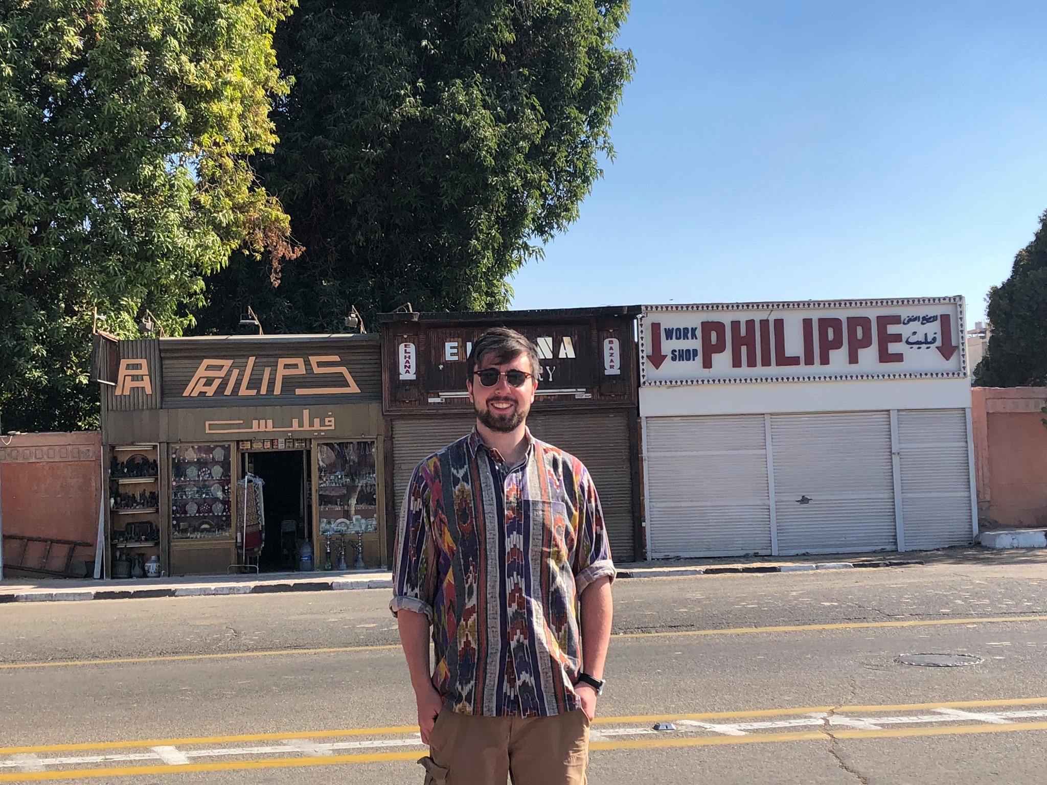 Philip Walsh standing in front of shops with his name